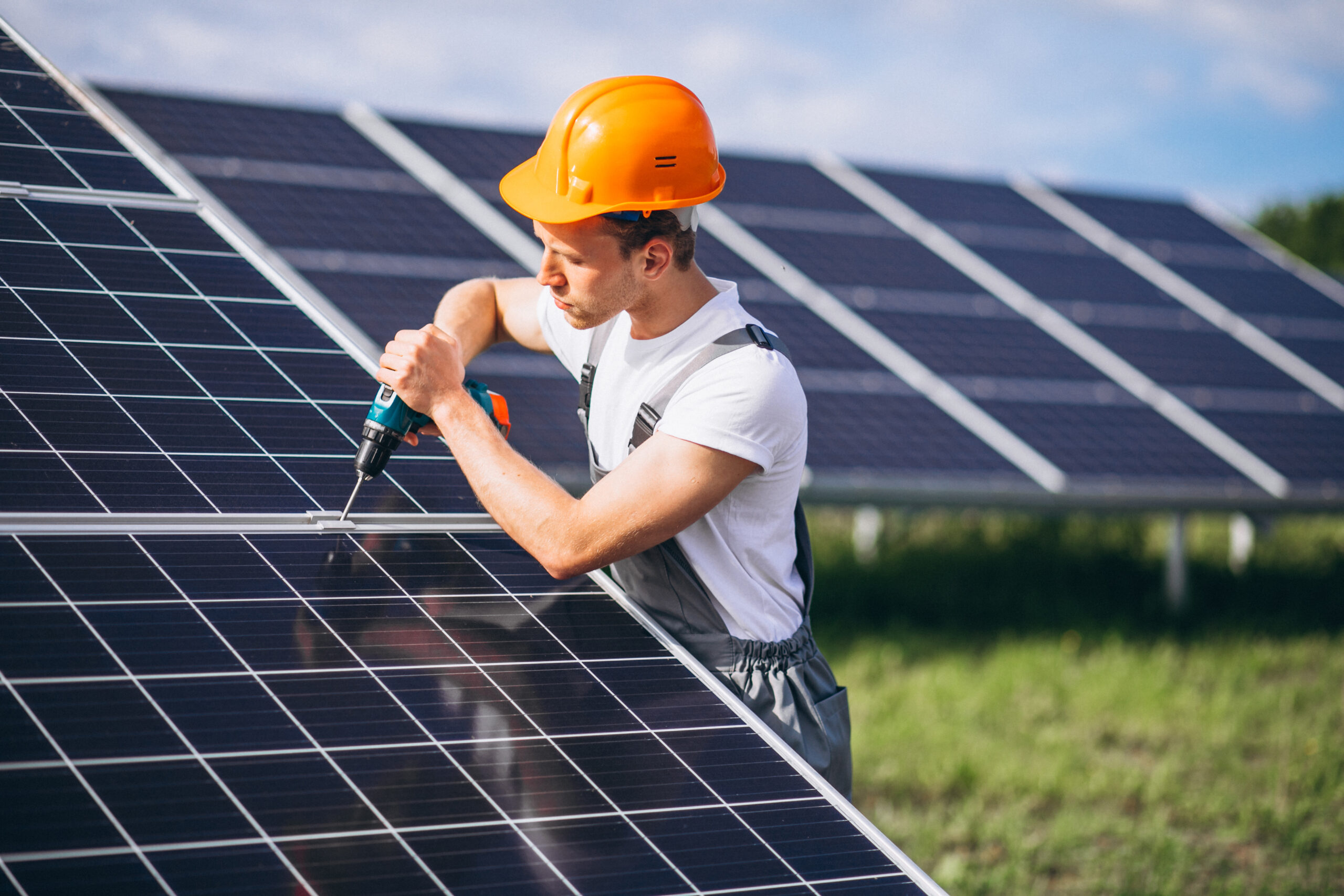 Man worker in the firld by the solar panels Man worker in the firld by the solar panels